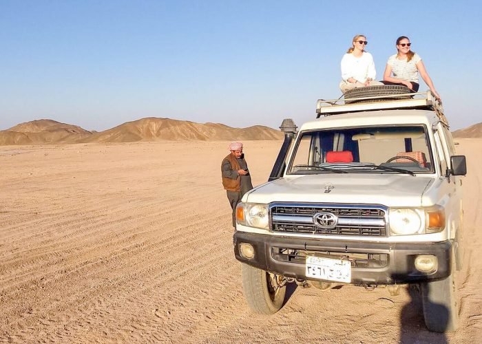 A-wonderful-shot-of-two-girls-sitting-on-a-four-wheel-drive-vehicle-from-a-safari-trip